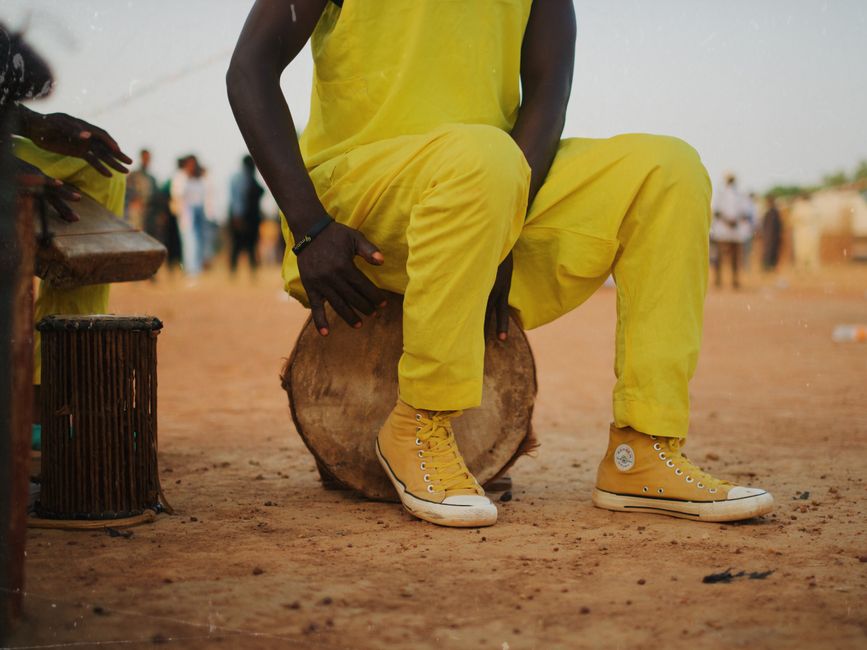 Vibrant outdoor drumming scene featuring colorful attire and dynamic energy.